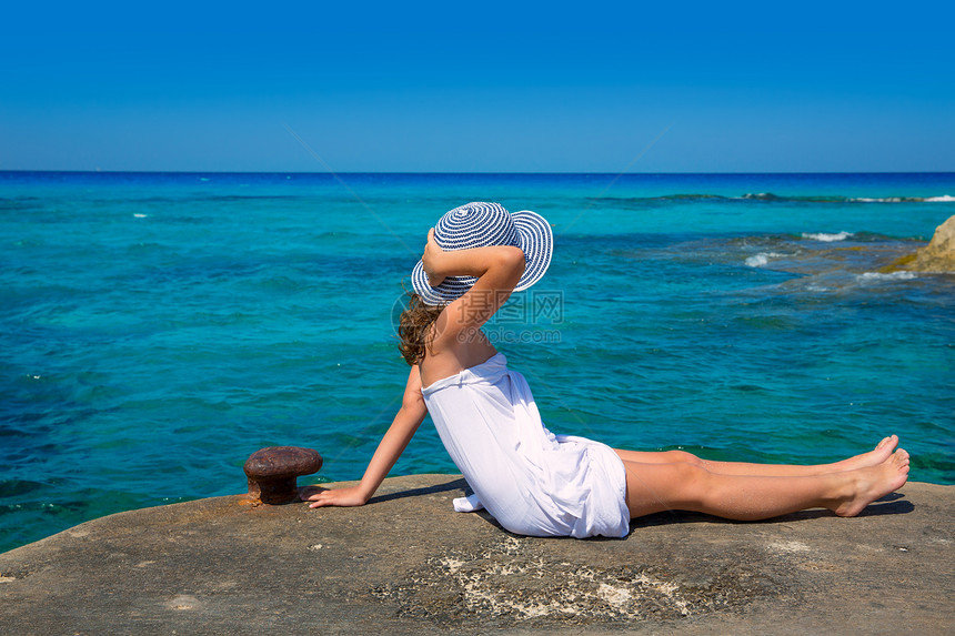 女孩在Formentera绿绿石地中海的海滩观望裙子女性海岸线支撑假期游客帽子码头地平线海洋图片