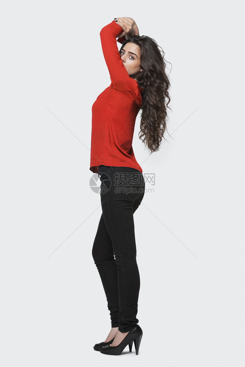 一名身陷灰色背景的年轻女性的概况图片