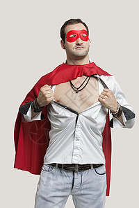 穿着彩色超级英雄穿着超级英雄服装的年轻人站在灰色背景下站立红色男子戏服英雄成人纽扣愿望影棚想像力休闲背景