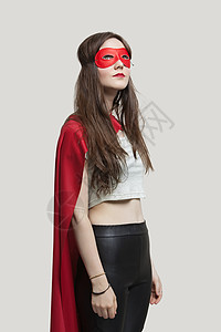 穿着彩色超级英雄穿着超级英雄服装的年轻女性 在灰色背景下抬头背景