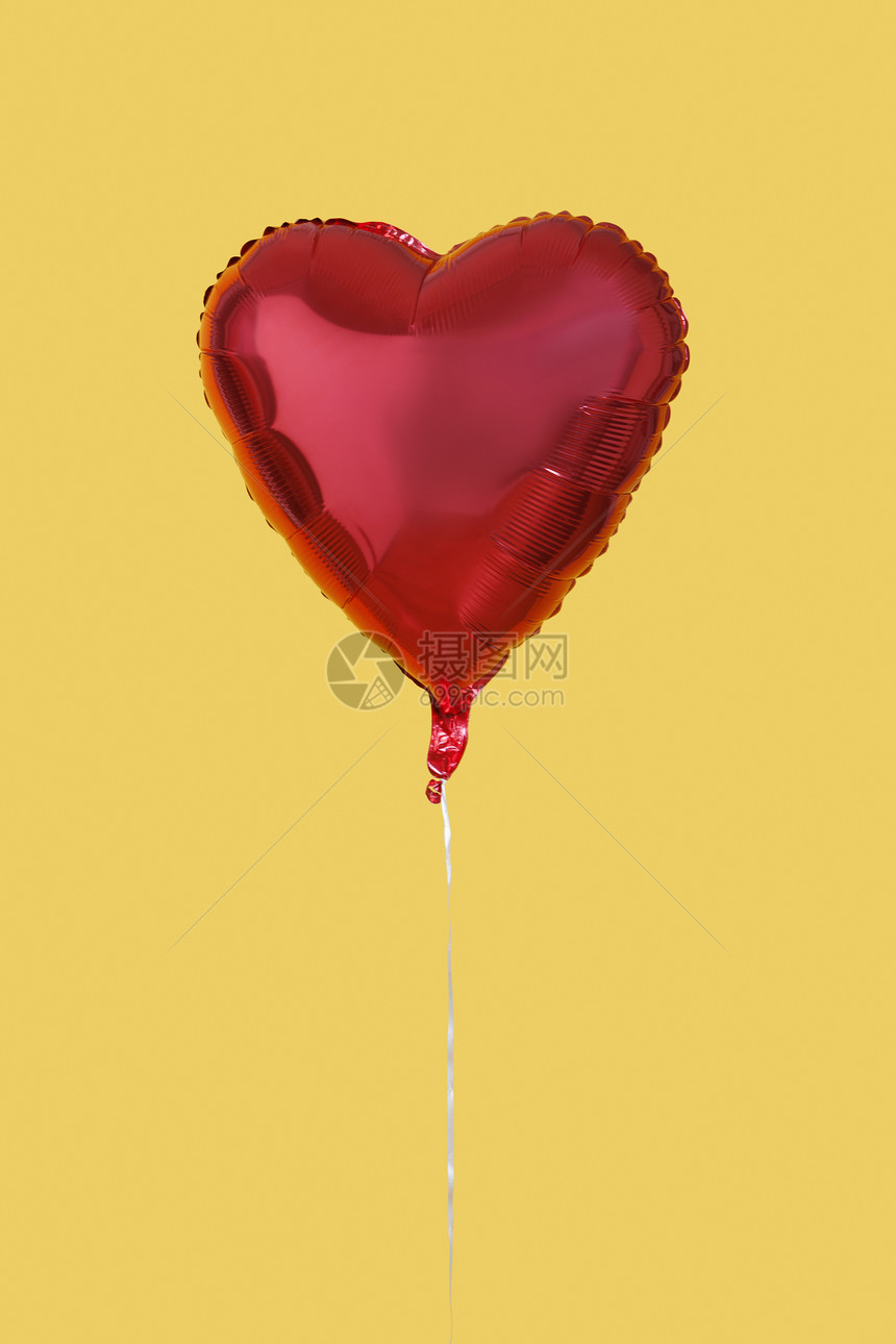 黄色背景上的红心形气球图片