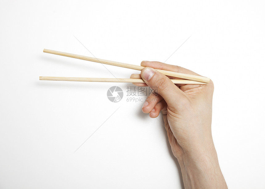 男人用手在白背景上抓筷子图片