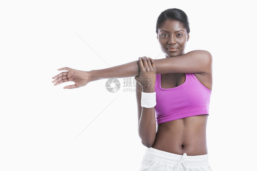 一位非裔美国年轻女子的肖像 将手臂伸展在白色背景上成人身体素质影棚运动粉色闲暇成年拉伸文胸女性图片