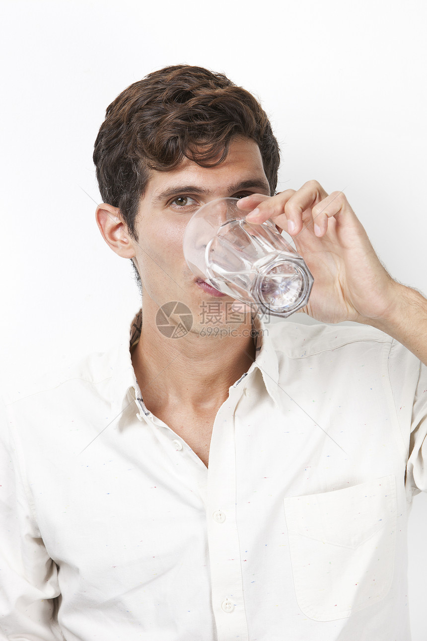 白色背景下年轻人饮用水的肖像 在白背景下饮用水图片