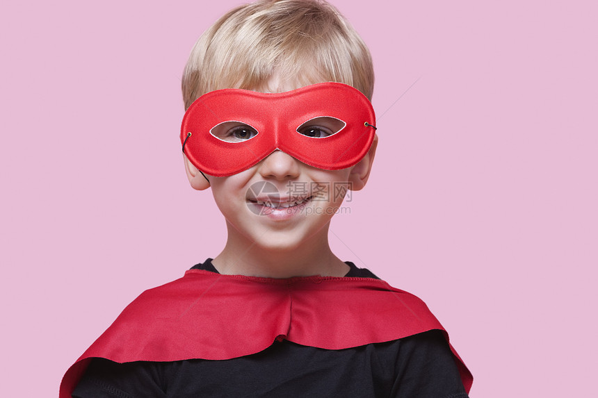 穿着超英雄服装的快乐男孩的肖像 粉红背景图片