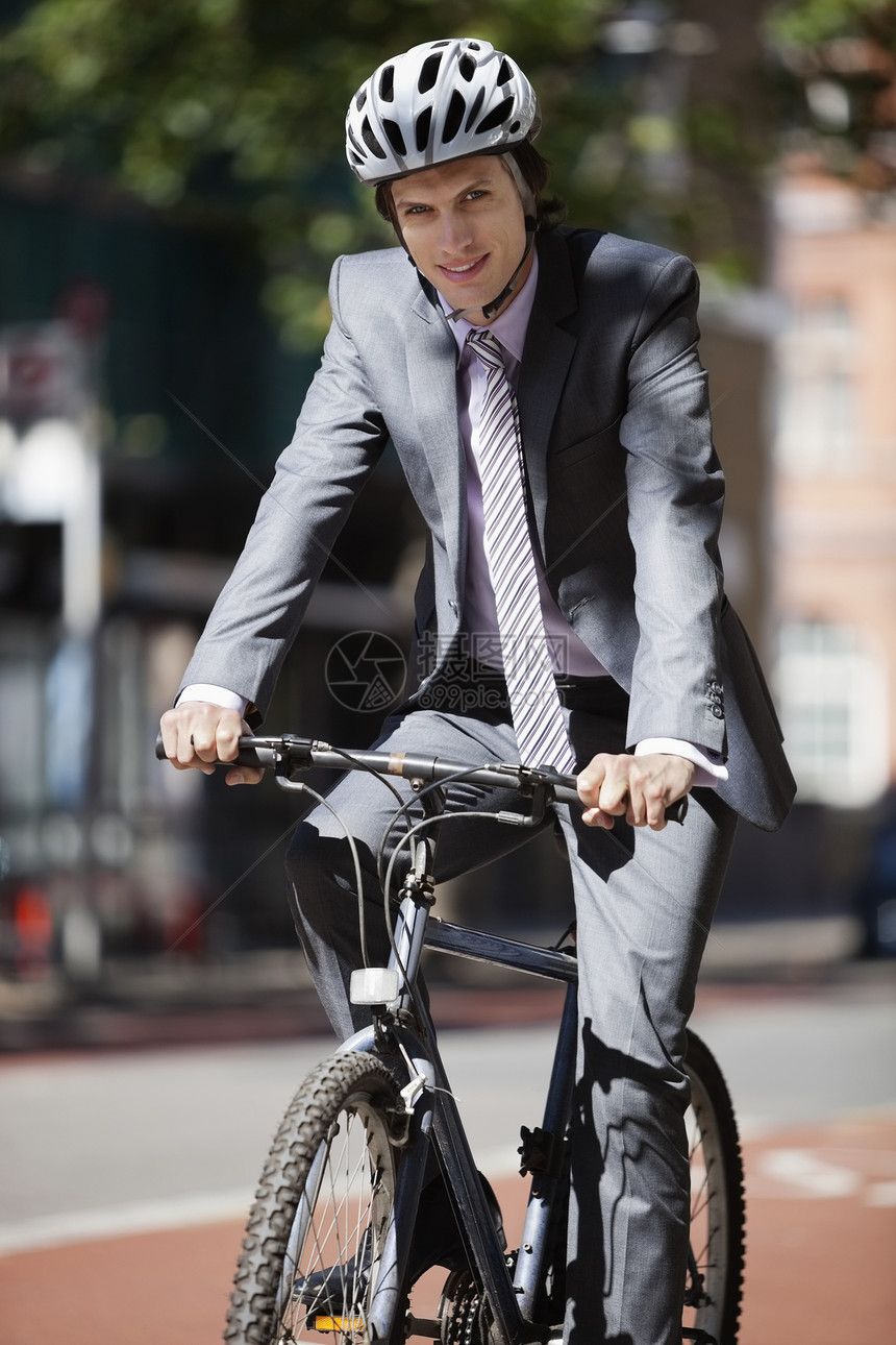 青年商务人士骑自行车的肖像;图片