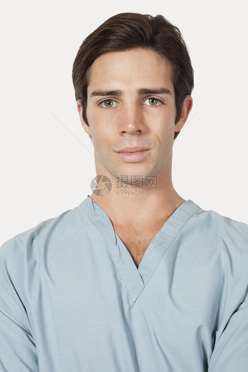 在灰色背景上用手术清洗器 描绘充满自信的年轻人的肖像图片