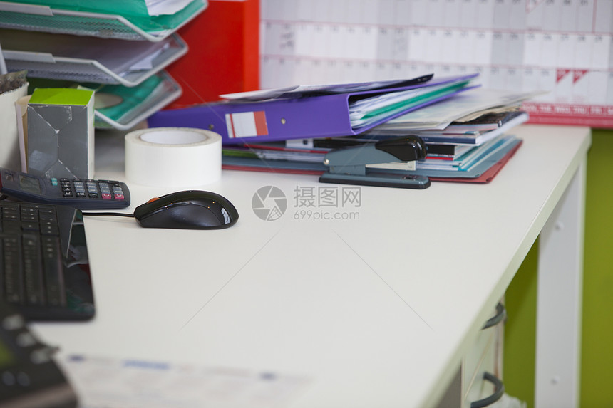 特写办公室内真实生活中的乱七八糟的办公桌鼠标便签电脑家具现实石灰绿技术文件夹桌子键盘图片