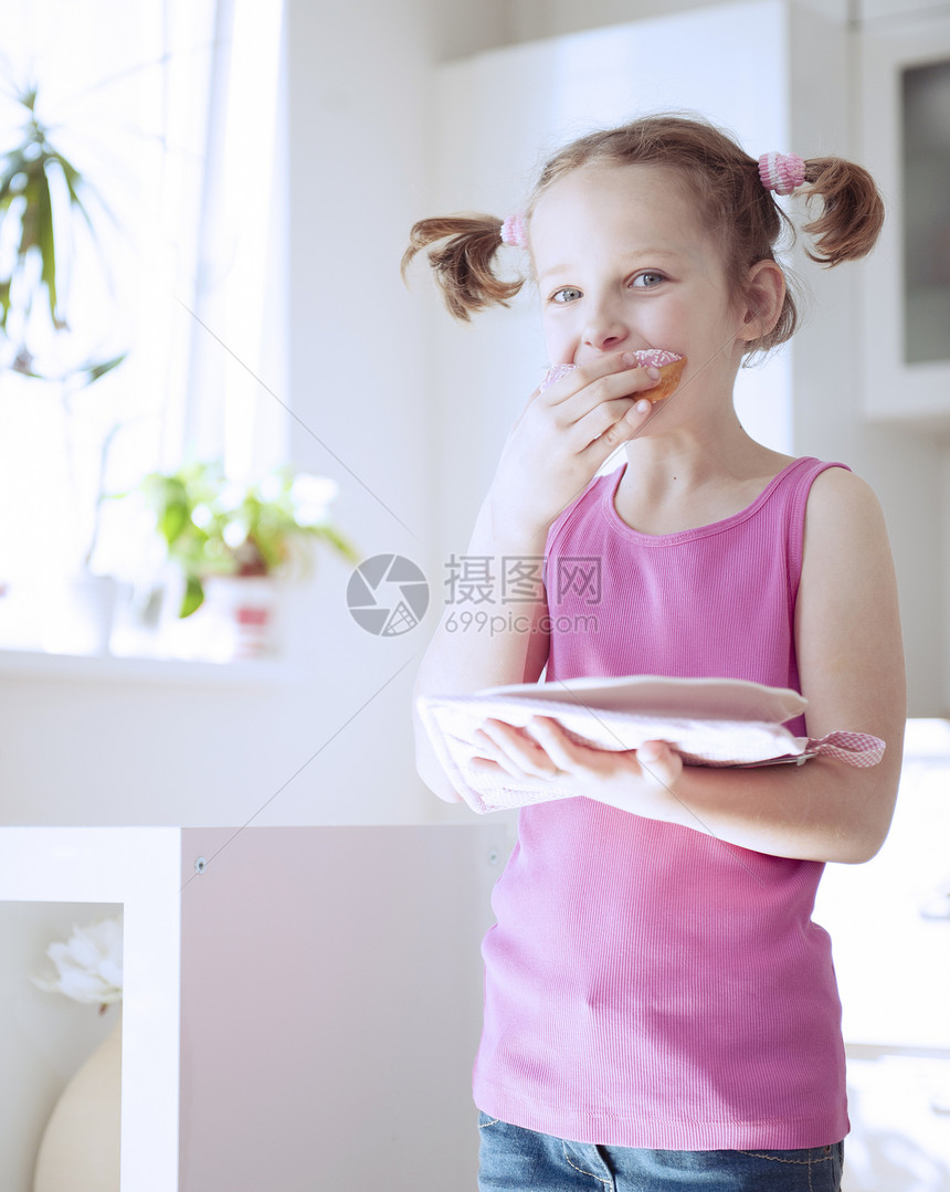 年轻女孩在厨房吃蛋糕房间食品贪婪衣服孩子青年童年粉色食物表情图片