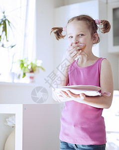 猪能吃的叫湿垃圾年轻女孩在厨房吃蛋糕房间食品贪婪衣服孩子青年童年粉色食物表情背景