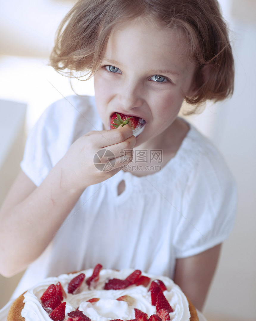 以蛋糕吃草莓为蛋糕的年轻女孩图片