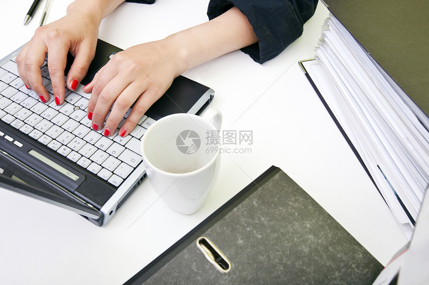 近身女性手用文件夹和杯子在笔记本电脑上打字房间学生茶杯桌子托盘商业西装女士视图实习图片