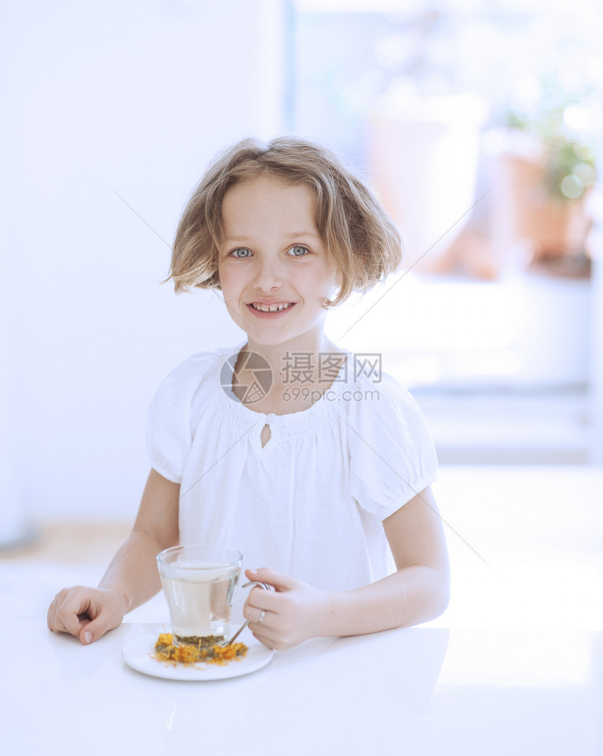 带茶和鲜花的年轻女孩食物表情白色玻璃杯花朵衣服花草童年房间女性图片
