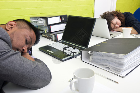 同事在各自的办公桌睡着男性办公室午睡人士男人女士电脑衣服石灰绿技术背景图片