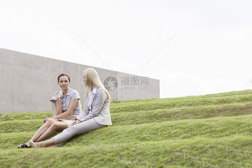 坐在草地上与天空对立的女商务人士人数图片