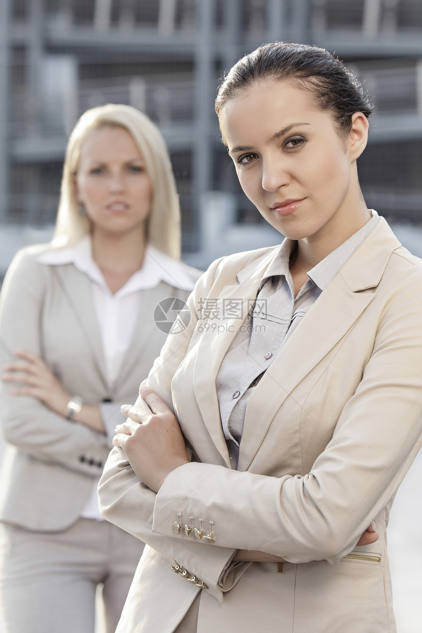 充满自信的年轻女商务人士站起双臂穿过户外生意人职业两个人办公楼西装焦点前景成年人商业高管图片