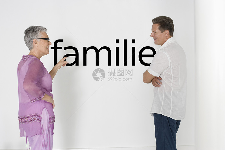 讨论家庭问题与白墙对立的一对夫妇 用德语文本“Familie”来讨论家庭问题图片