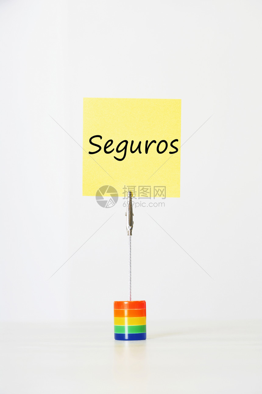 带有西班牙文文本“seguros”(保险)的粘贴纸纸 剪切成多色卡持有者图片