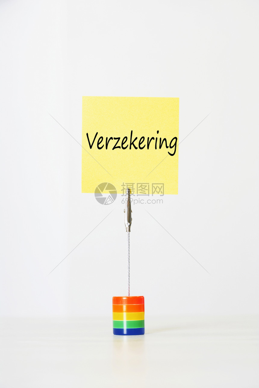 荷兰文本“Verzekering”(保险)的粘贴纸纸 被剪切到多色卡持有者手中图片