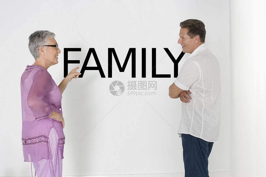 讨论家庭问题反对白墙的一对夫妇用英文文本图片