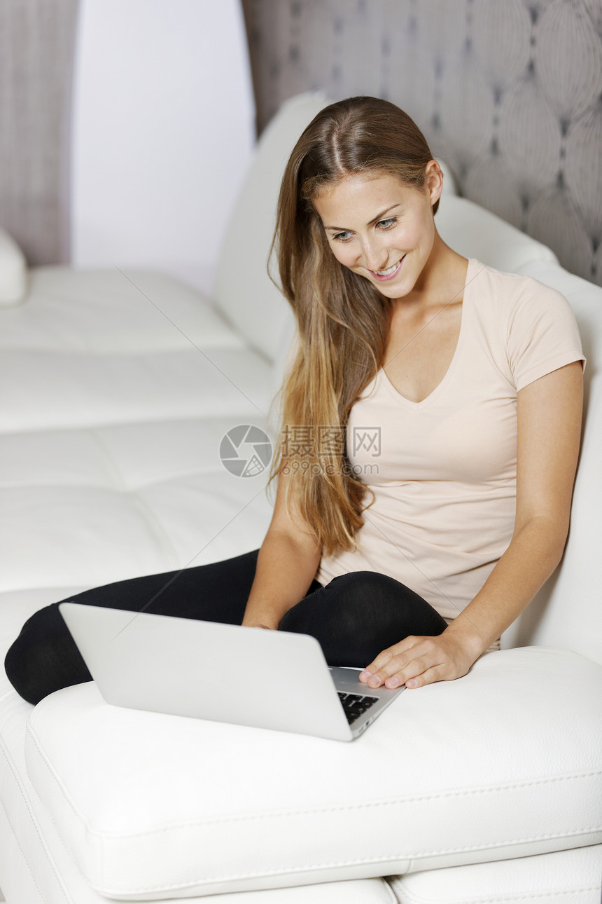 妇女在家里使用膝上型电脑女士电子邮件沙发女孩椅子快乐互联网工作女性笔记本图片