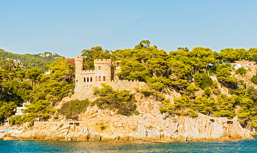 西班牙的中世纪城堡目的地岩石海岸线树木旅行背景图片