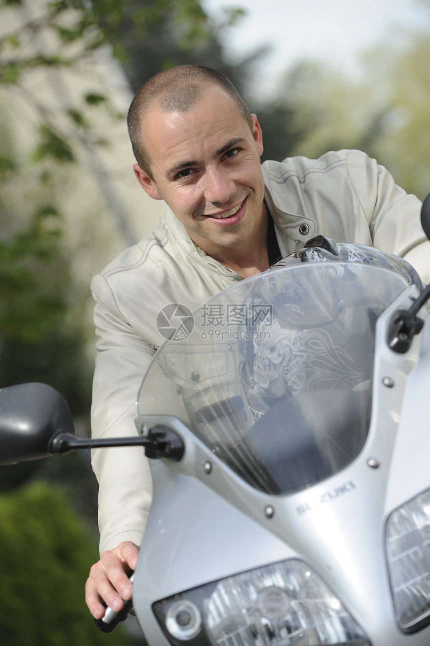 骑摩托车的年轻人热情驾驶机器执照外貌头盔黑色乐趣男人白色图片