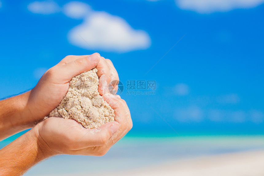 人类握着白色热带海滩的手 形成心脏形状背景 海海假期一部分压痛闲暇海洋情调蓝色男人手指手镯图片
