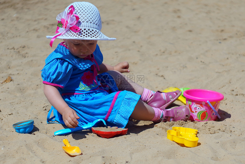2岁女孩在沙箱里玩街道帽子沙坑创造力童年模具连衣裙游戏蓝色图片