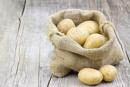 土豆生土豆 包装布袋中解雇收成鱼种食物市场马铃薯生产块茎蔬菜麻布背景图片