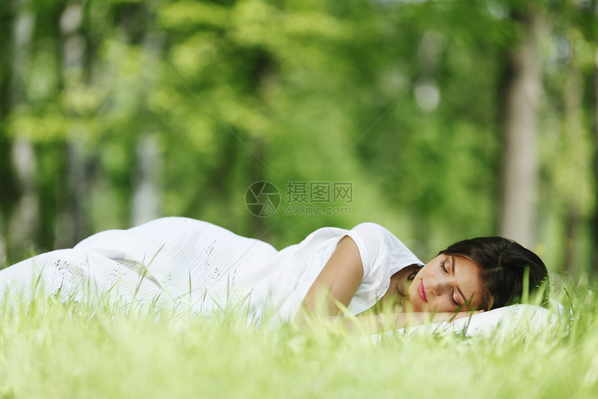 睡在草地上的女人自由场地女孩绿色毯子白色枕头睡眠公园女性图片