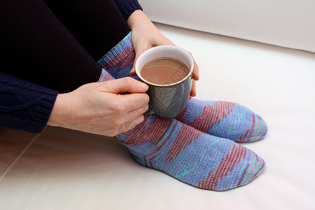 女人喝热饮 穿暖和针织袜子高清图片