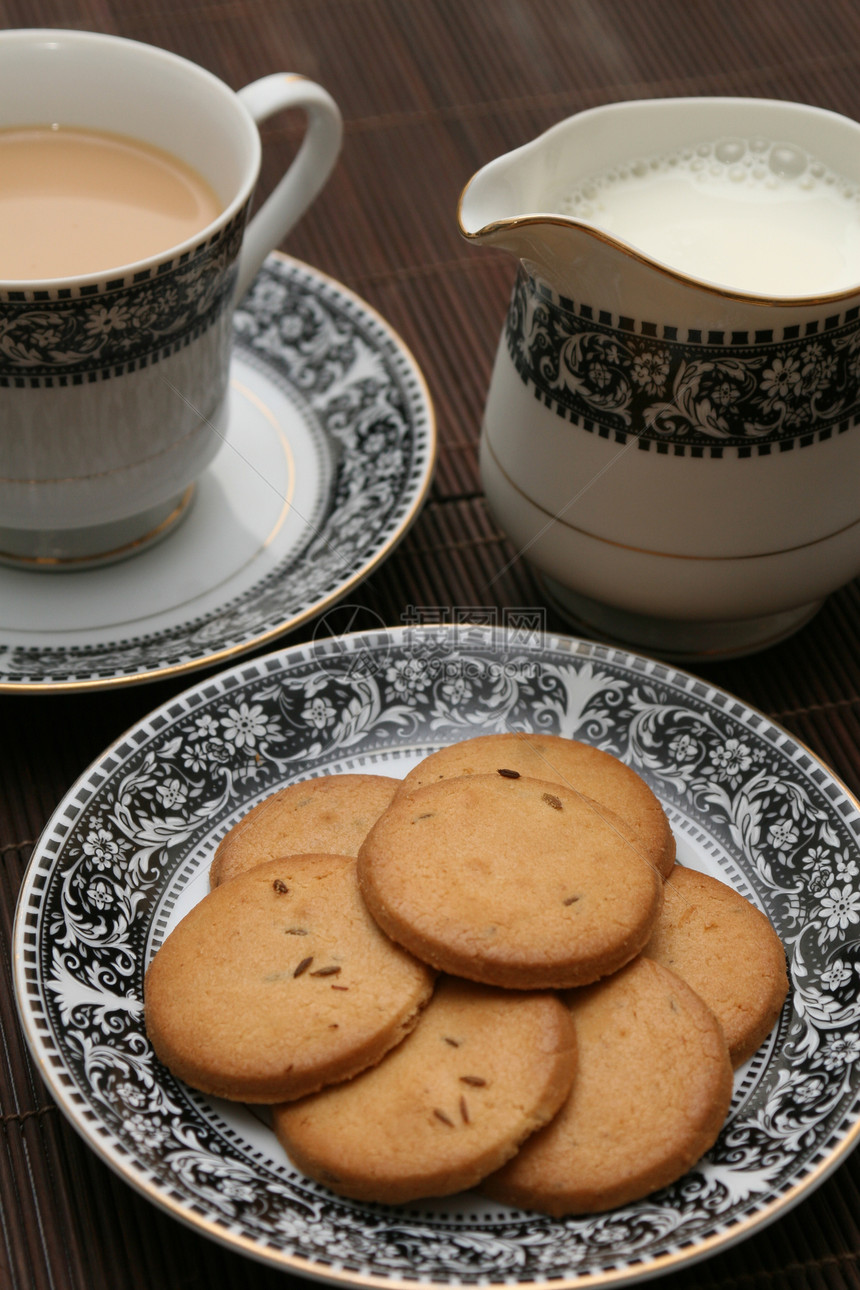 装满了饼干的盘子加牛奶壶和一杯茶芳香桌子美食巧克力杯子陶瓷甜点食物蛋糕宏观图片