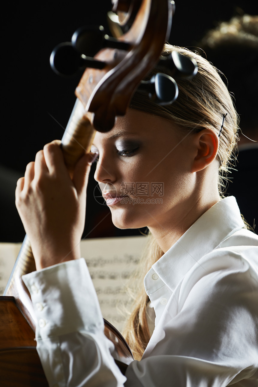 音乐会中的大提琴手专注天赋女孩娱乐乐队古典音乐女子音乐家乐谱乐器图片