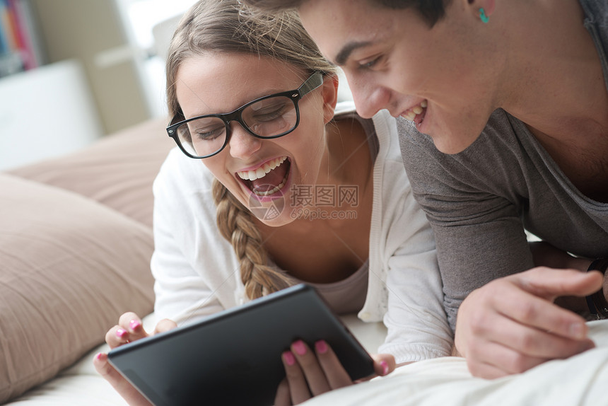 配有数字平板电脑的幸福夫妇技术男性男朋友青少年夫妻数位板朋友们女朋友快乐卧室图片