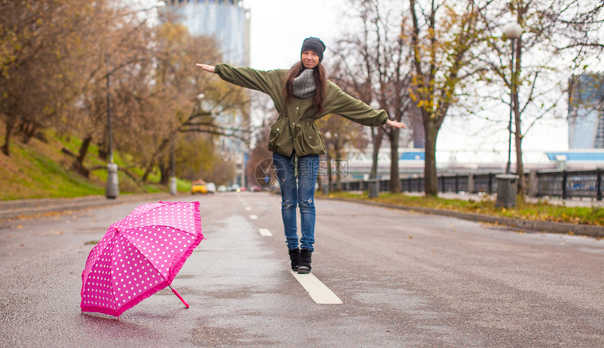 秋天下雨日 年轻女子带着雨伞行走成人城市寂寞衣服微笑雨衣女性雨量闲暇披风图片