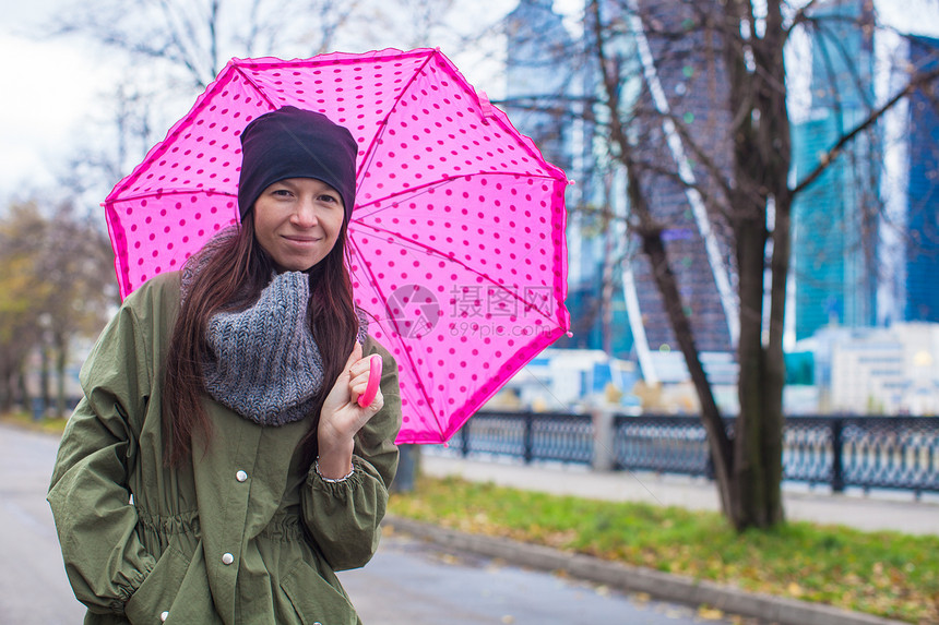 秋天下雨日 年轻女子带着雨伞行走雨量季节幸福微笑外套城市雨衣寂寞成人衣服图片