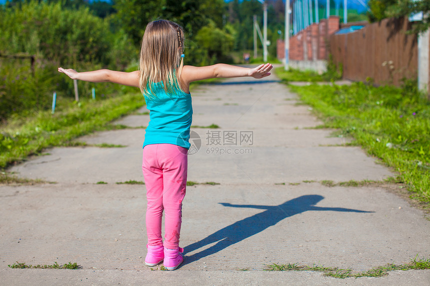 小女孩走在户外 玩得开心女性幸福乐趣亮度快乐跑步孩子童年村庄蓝色图片