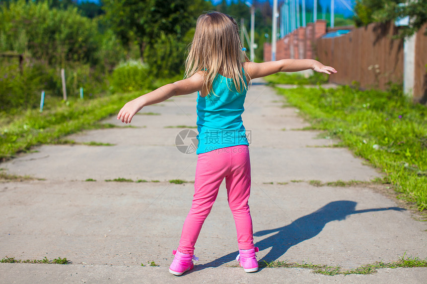 小女孩走在户外 玩得开心村庄幸福亮度童年女性阳光孩子快乐蓝色跑步图片