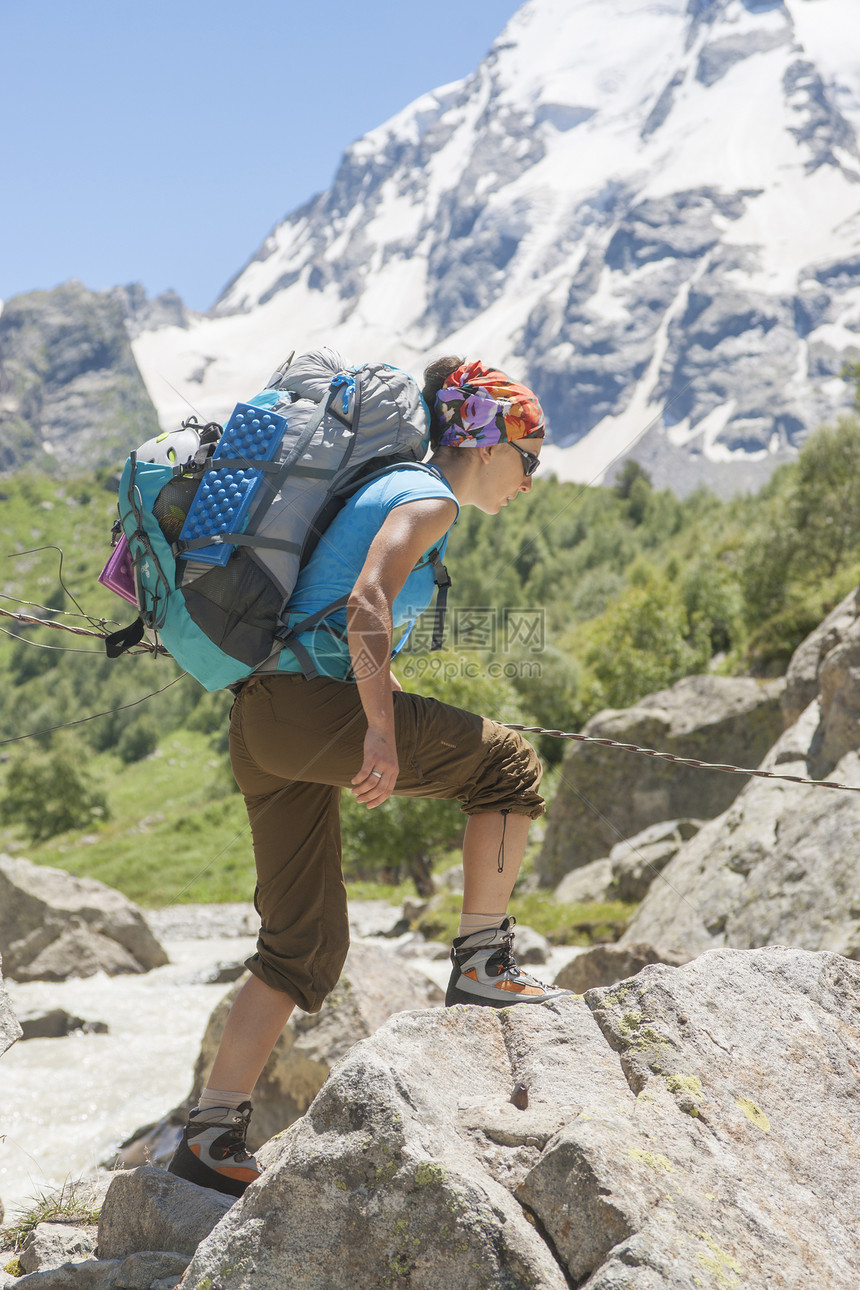 青年女子在山上远足旅行女孩冒险天空闲暇岩石背包远足者活动男性图片