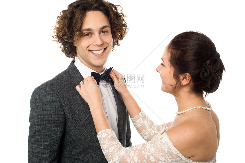 新娘调整她男人的领结快乐婚姻夫妻裙子丈夫工作室新人订婚套装冒充图片