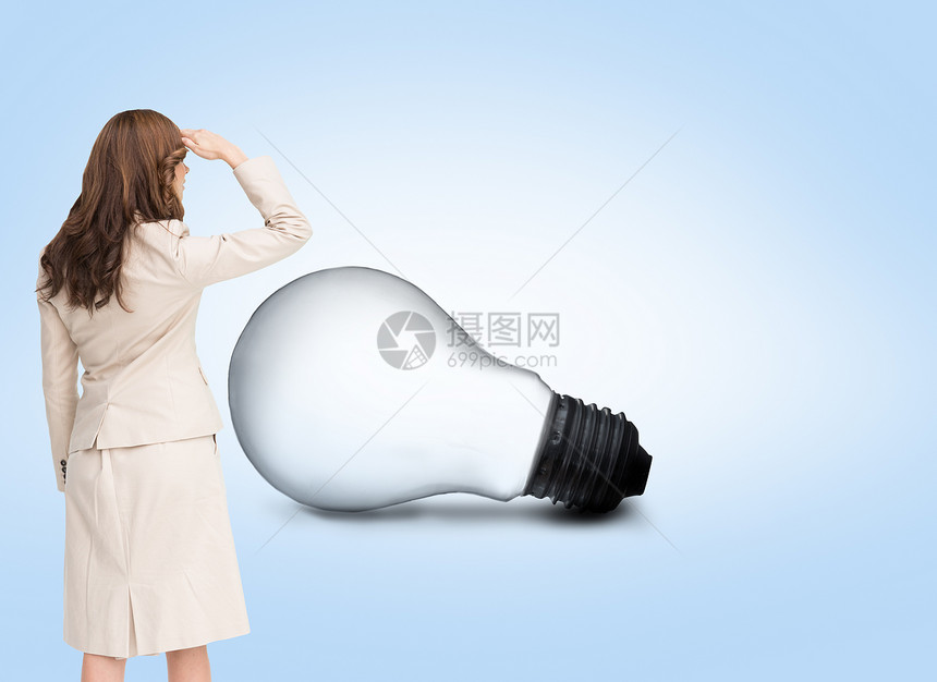 年轻女商务人士向远方看的复合后视图像头发计算机蓝色夹克专注商务女性棕色背景灯泡图片