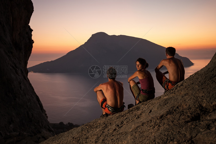 日落时休息的三位攀岩者电话女士运动娱乐岩石团体男性高度男人伙计们图片