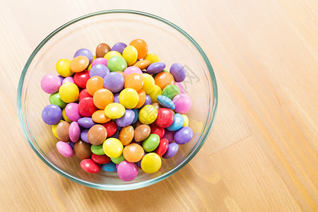 圆形果冻按钮巧克力在碗中的糖果食物红色棕色垃圾圆形甜点绿色黄色蓝色白色背景