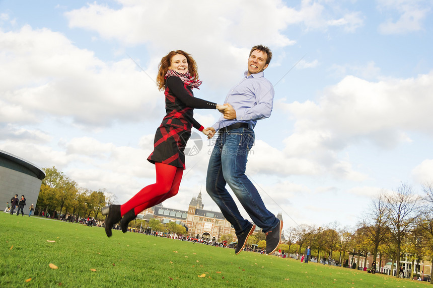 户外快乐的情侣在阿姆斯特丹博物馆城跳跃季节性男人享受微笑拥抱女士夫妻男性博物馆季节图片