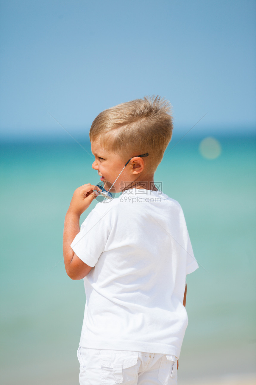 海滩上可爱的男孩男生假期活动幸福太阳镜热带情调喜悦眼镜快乐图片