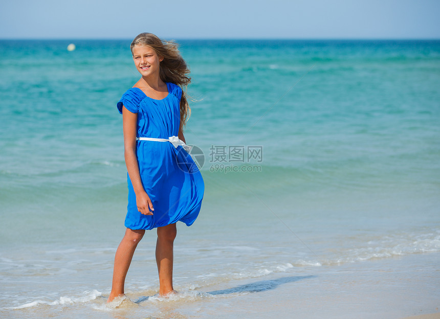 海滩上可爱的女孩太阳热带游泳衣海景裙子海洋微笑支撑快乐太阳镜图片