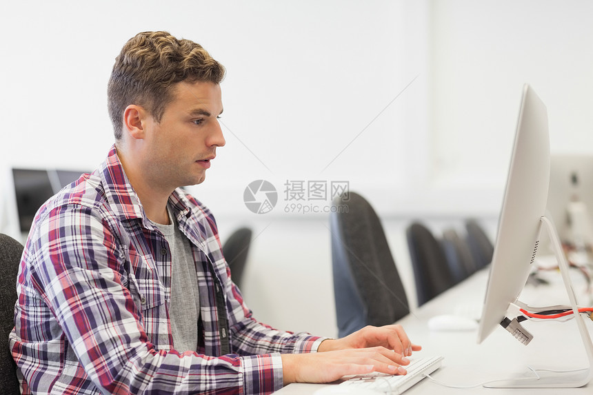 在计算机室工作的英俊 重点突出的学生图片