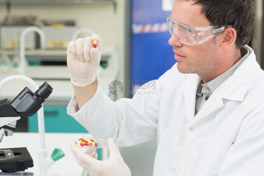 男性科学家分析实验室中的药片 在实验室中从业者保健治疗手套技术员审查科学专注样本专家图片