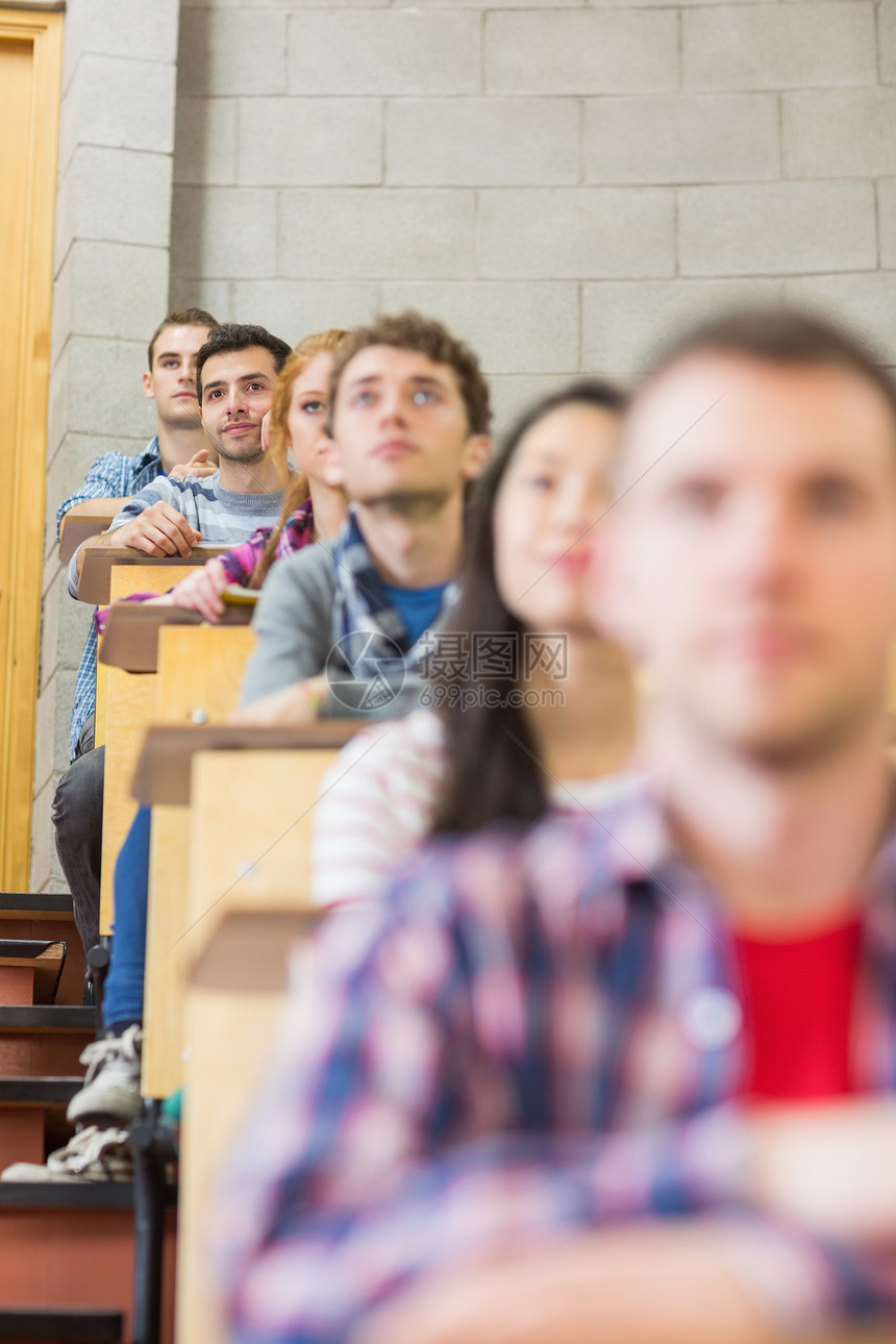 特写坐在教室里的年轻学生的近距离知识班级学校便服桌子男性女性混血同学们课堂图片